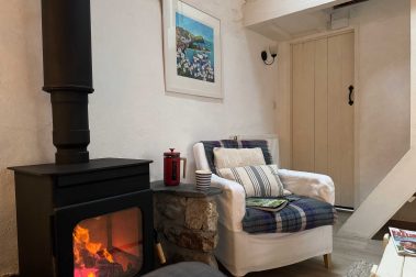 The sitting room has comfortable seating for six. There is a logburning stove and a smart TV.