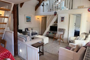 The cosy living room is open plan and has a light, bright feel. It is overlooked by the mezzanine bedroom above. The bathroom and downstairs double bedroom open directly into the living room.